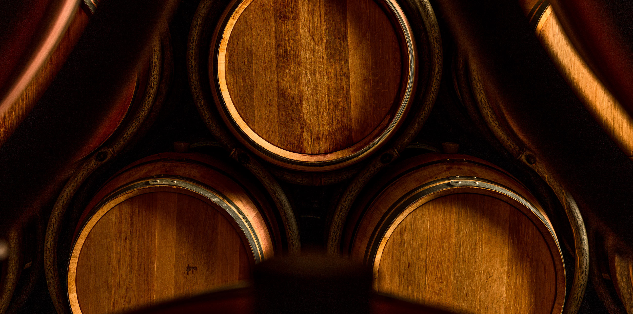 Close-up shot of three French oak barrels, stacked in a triangle, in Grgich Hills Estate's wine cellar.