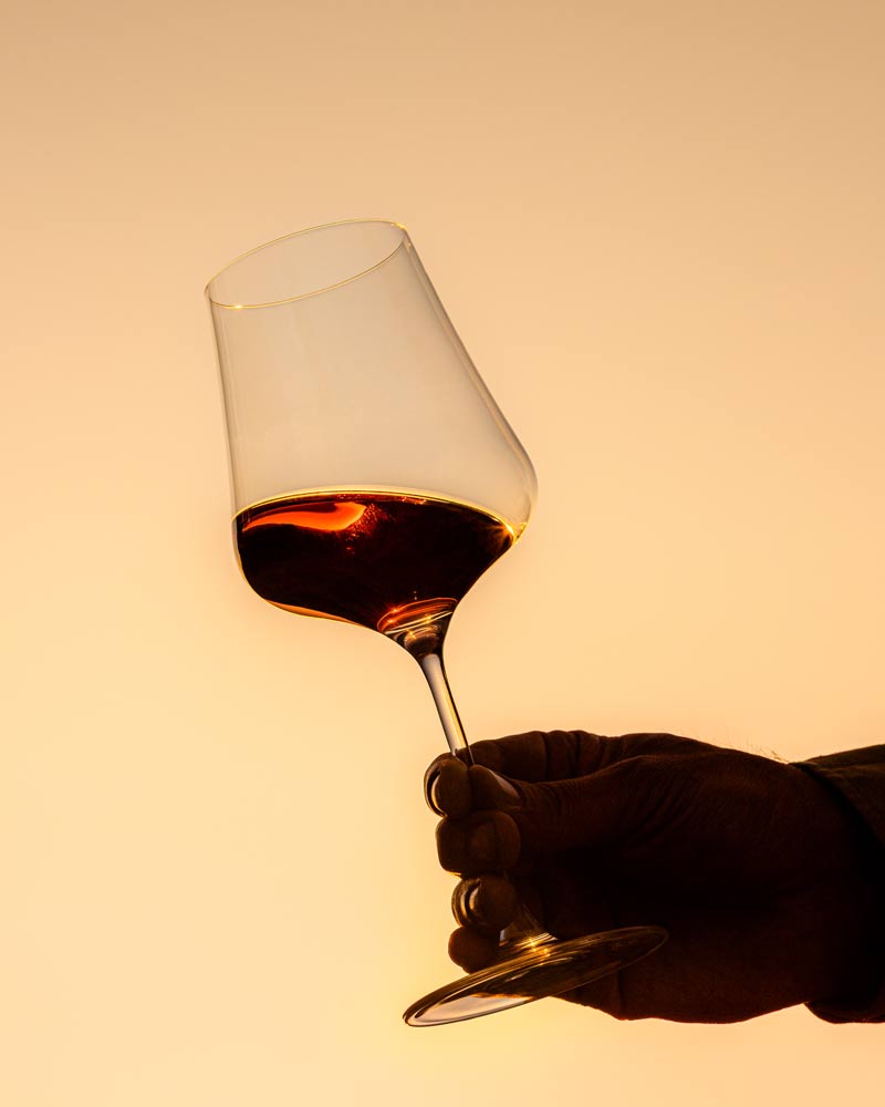 A wineglass being held up to the dusk sky in Napa Valley.