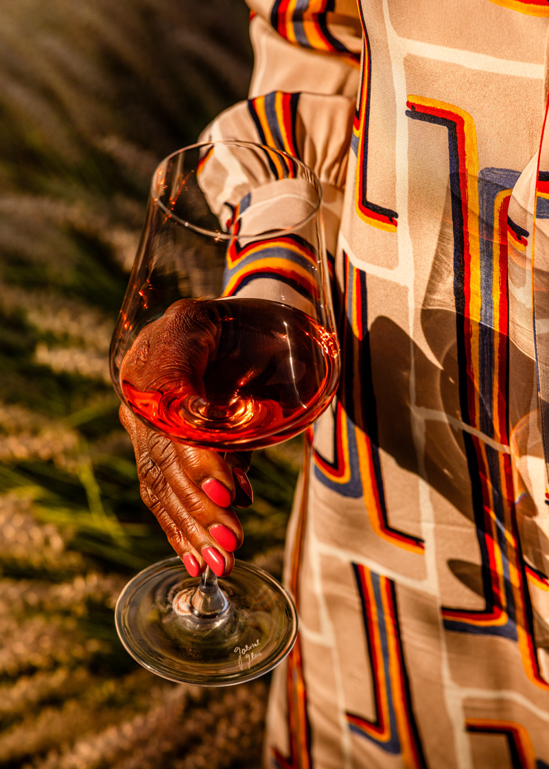 Ruby-red wine in a glass being held gently in hand.
